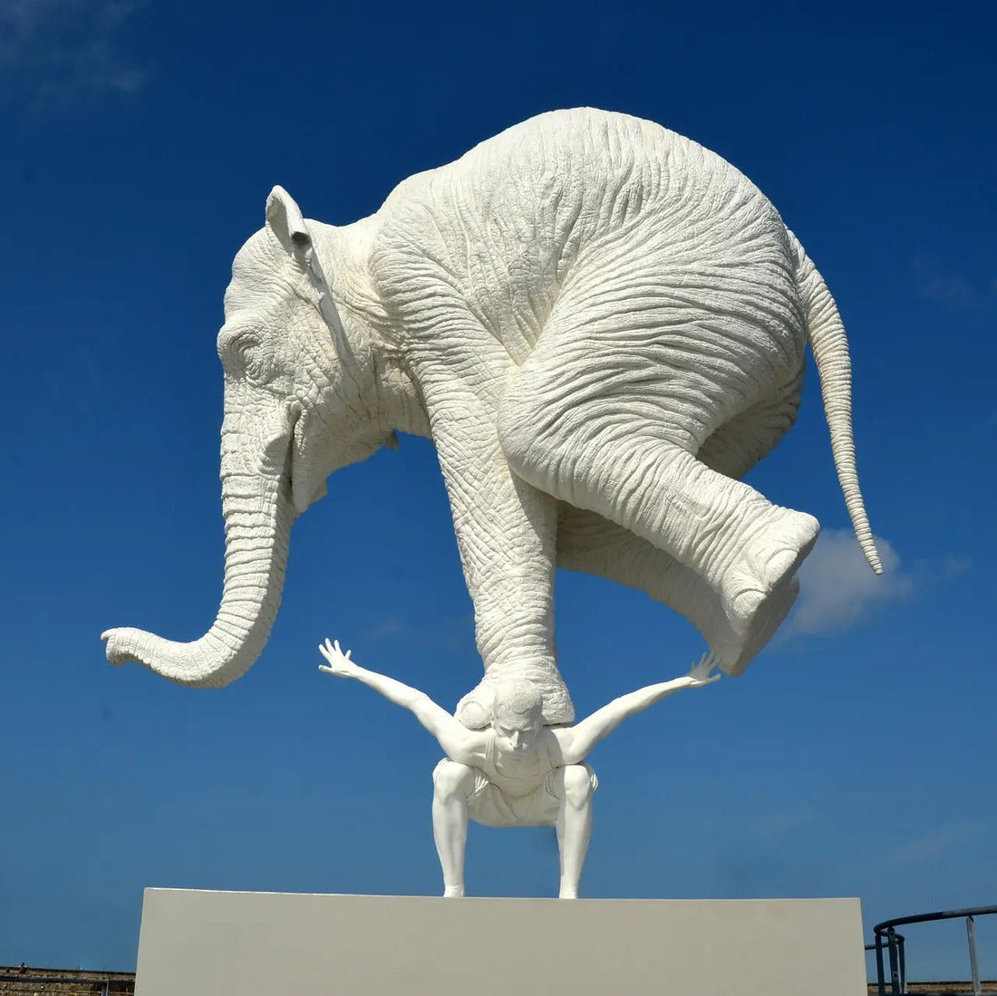 An elephant standing on top of a man symbolising pressure 