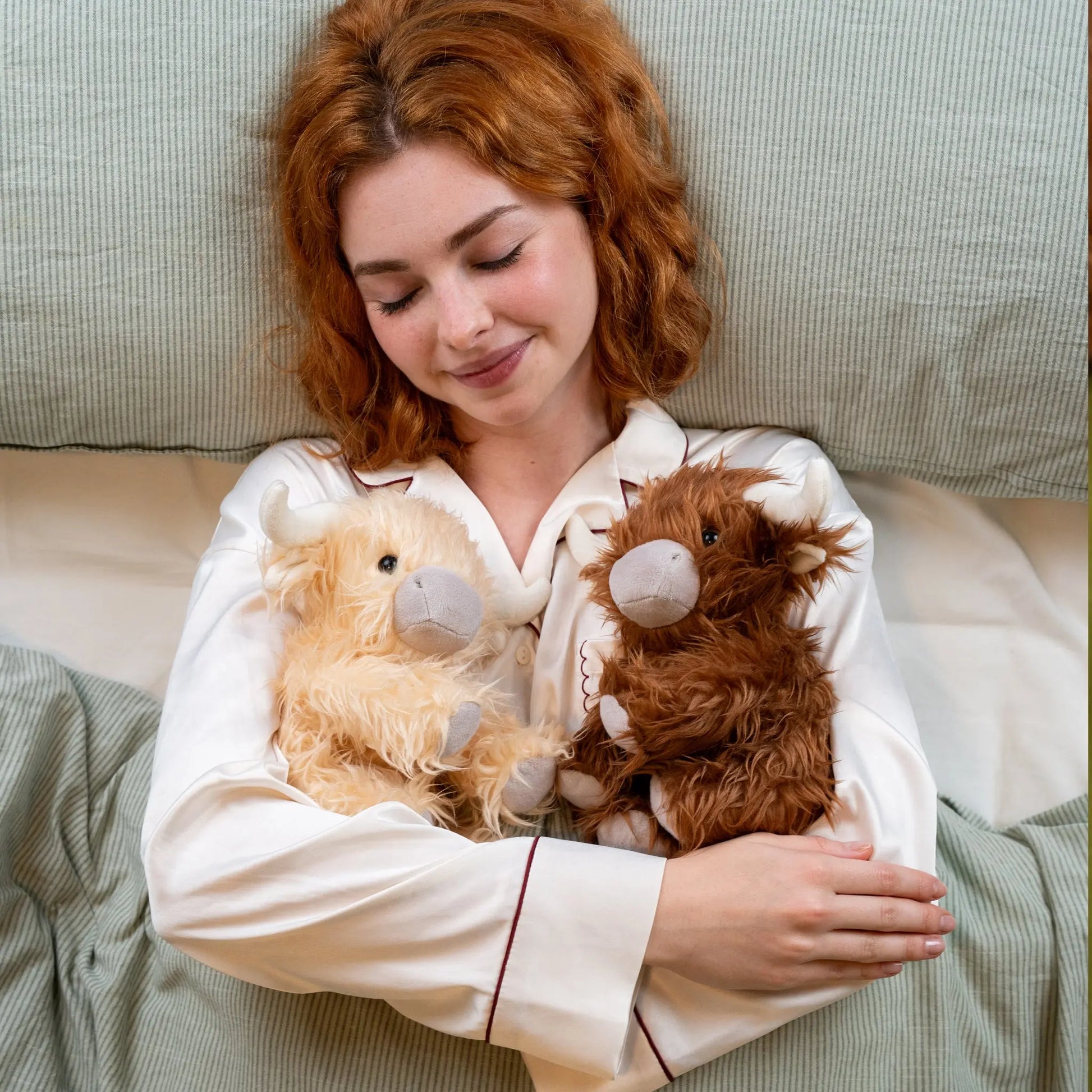 Woman in Pyjamas cuddles McCuddles weighted plush toys